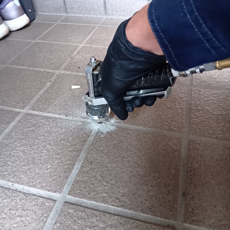 玄関の床にシロアリ駆除を注入する様子