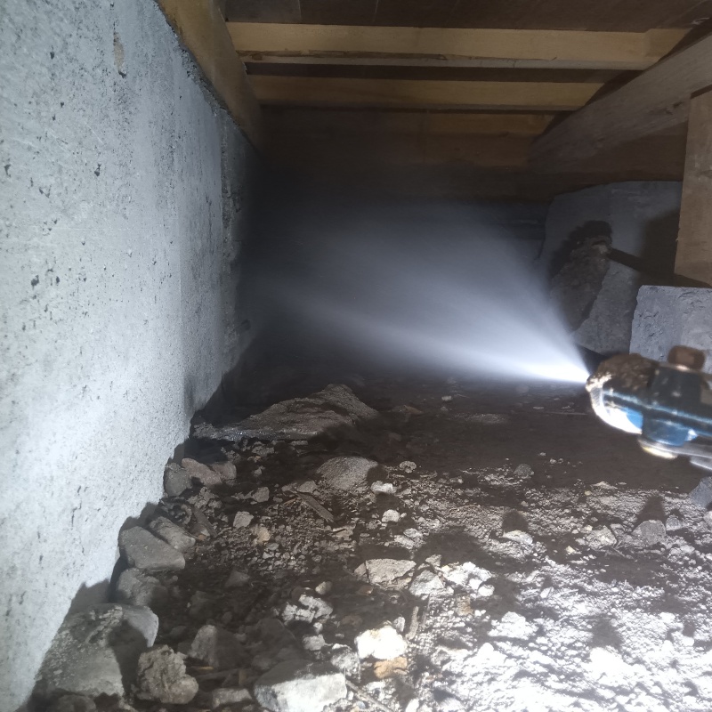 床下の土壌に防蟻剤を散布する様子