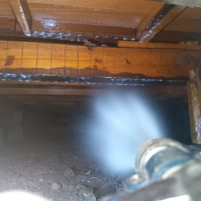 床下の土壌に防蟻剤を散布する様子