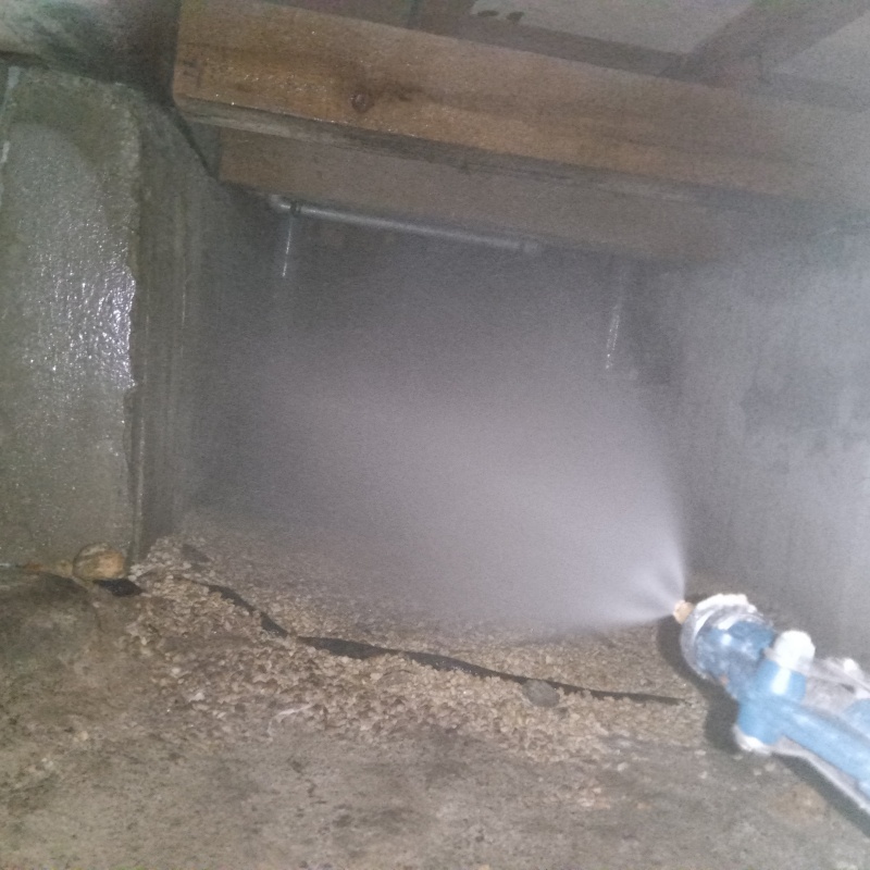 床下の土壌にシロアリ駆除を散布する様子