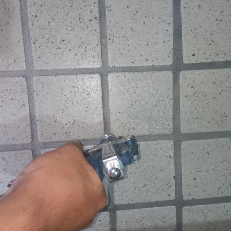 玄関の床にシロアリ駆除剤を注入する様子