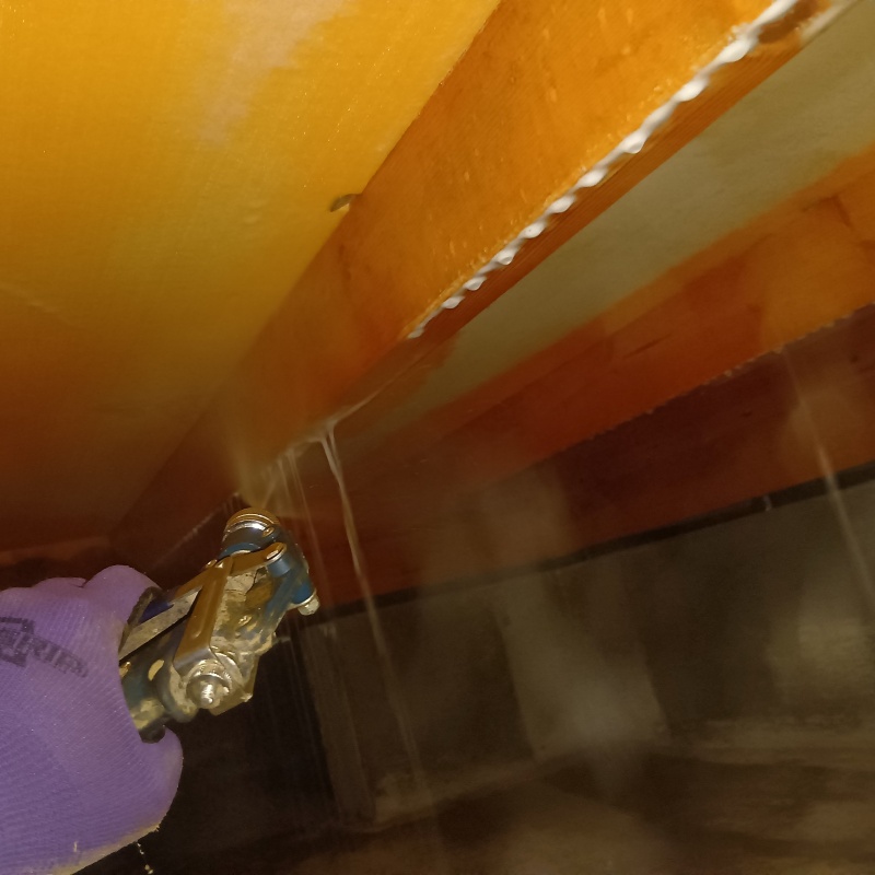 床下の木材にシロアリ駆除を散布する様子