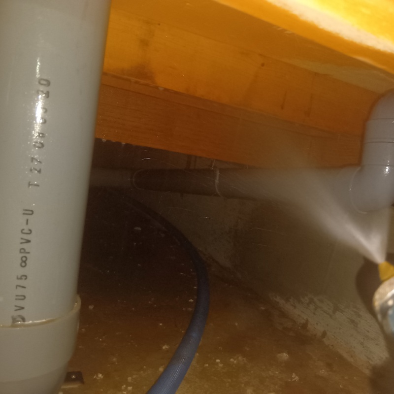 床下の木材にシロアリ駆除を散布する様子