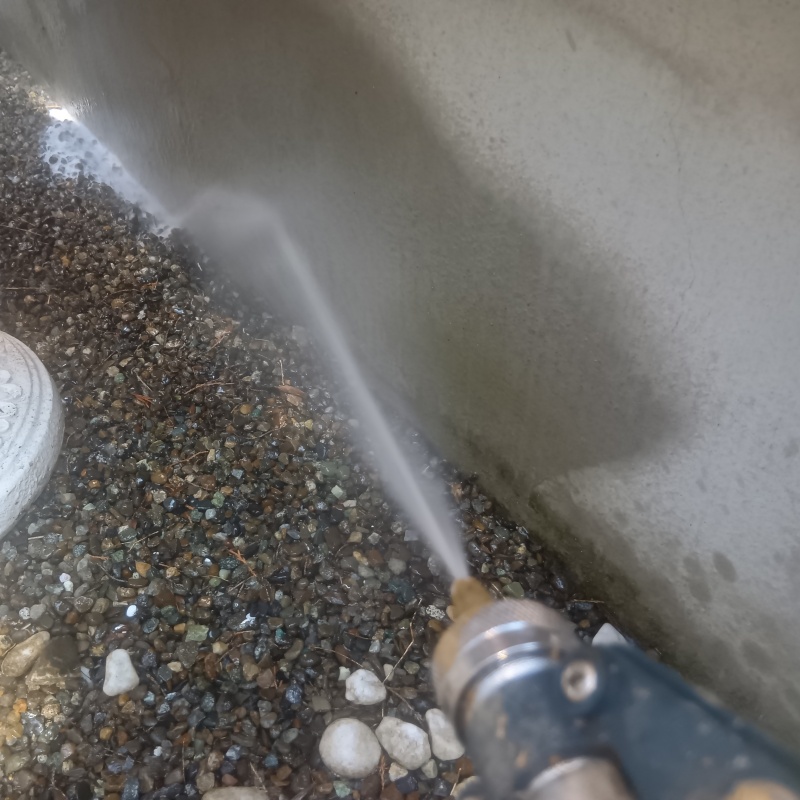 基礎まわりにシロアリ駆除を散布する様子