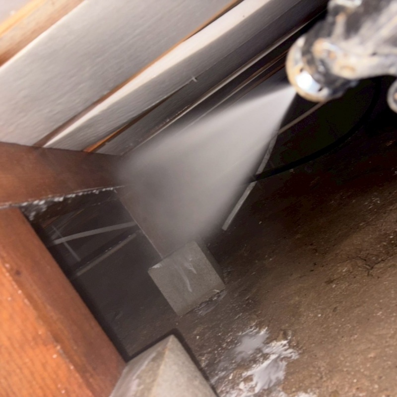 床下の木材にシロアリ駆除を散布する様子