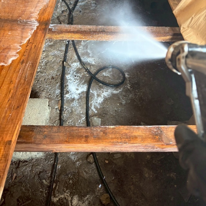 床下の土壌にシロアリ駆除を散布する様子