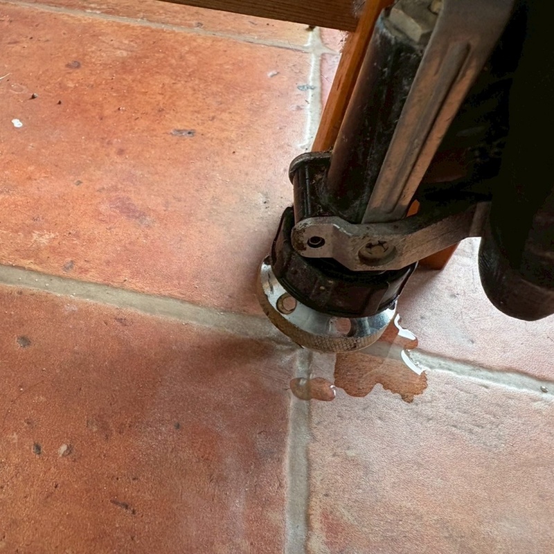 玄関の床にシロアリ駆除剤を注入する様子