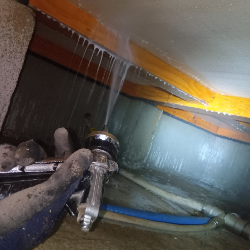 床下の木材にシロアリ駆除を散布する様子