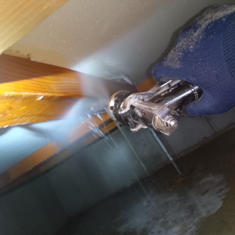 床下の木材にシロアリ駆除を散布する様子