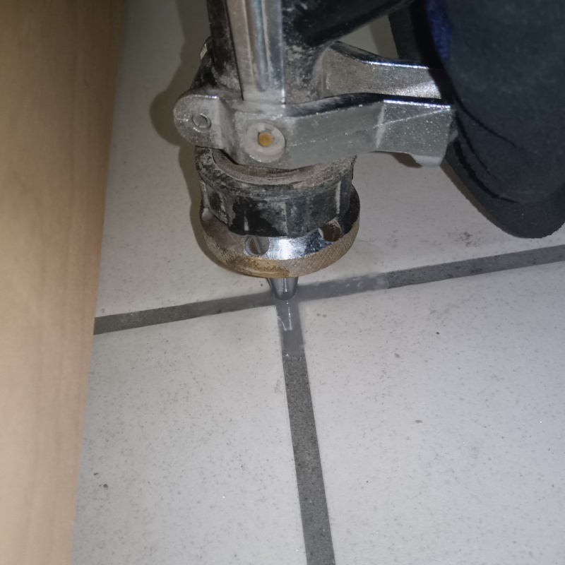 玄関の床にシロアリ駆除剤を注入する様子