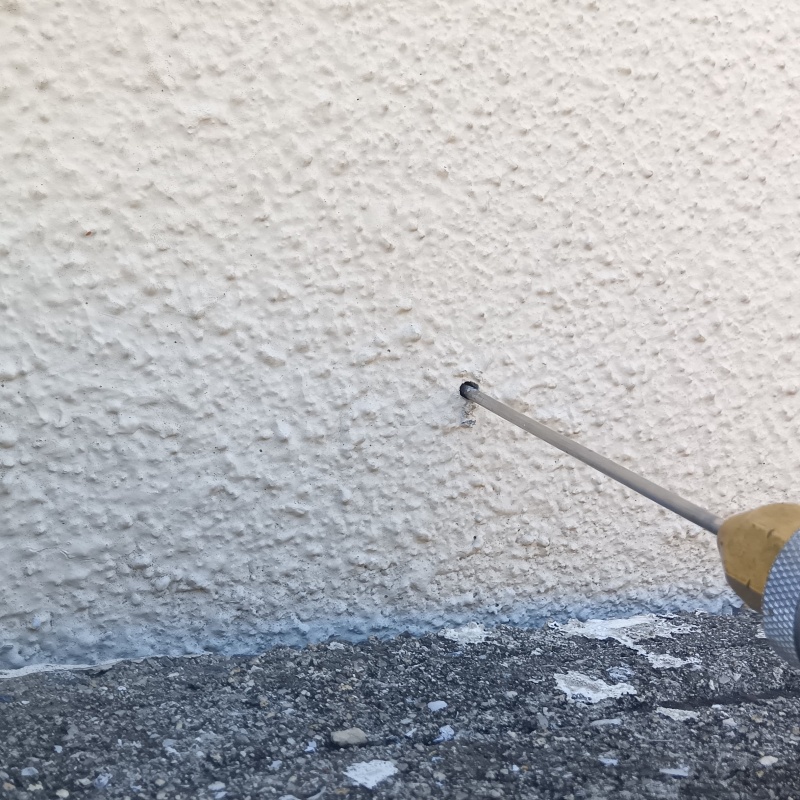 外壁にシロアリ駆除を注入する様子