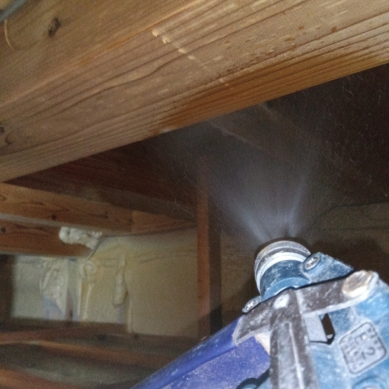 床下の木材にシロアリ駆除を散布する様子