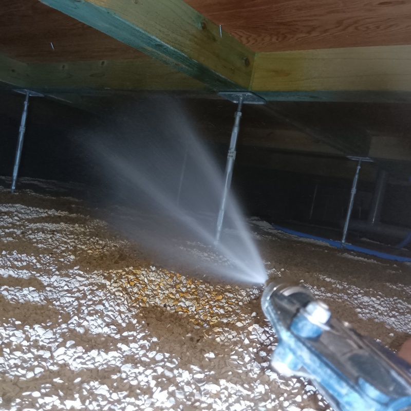 床下の土壌にシロアリ駆除を散布する様子