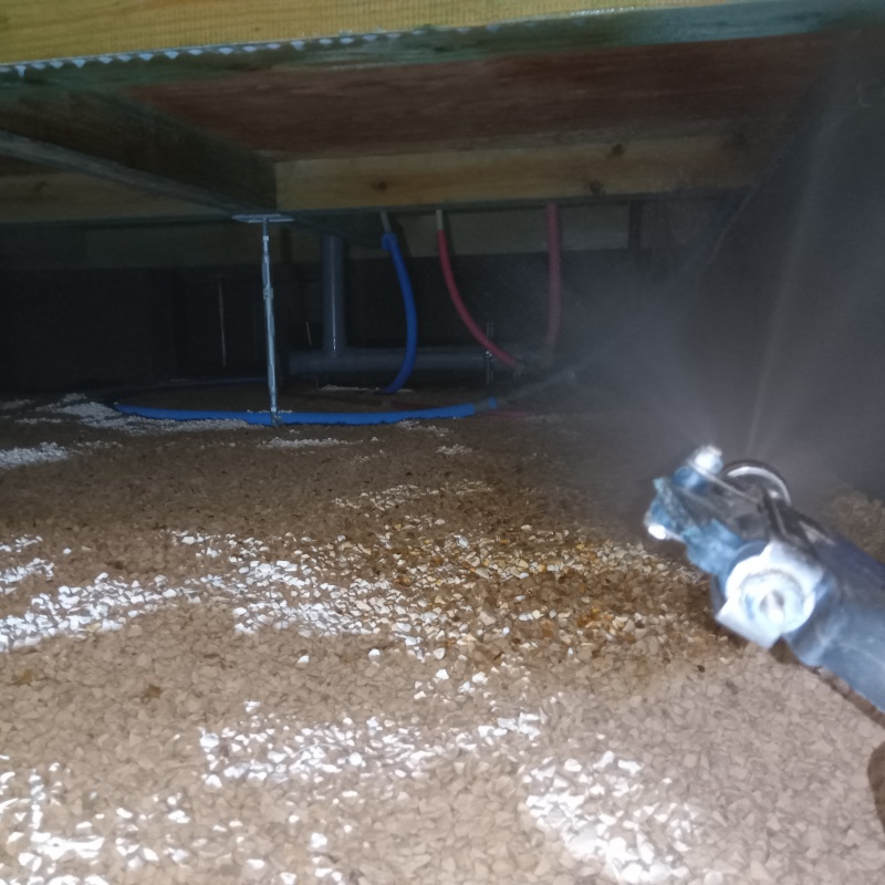 床下の土壌にシロアリ駆除を散布する様子