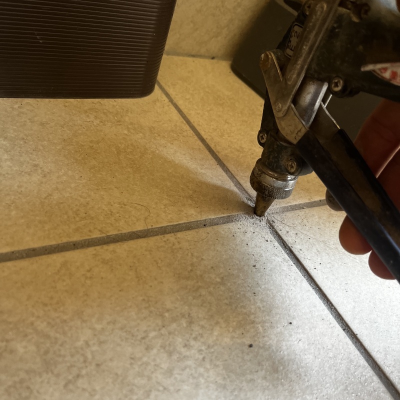 玄関の床に防蟻剤を注入する様子