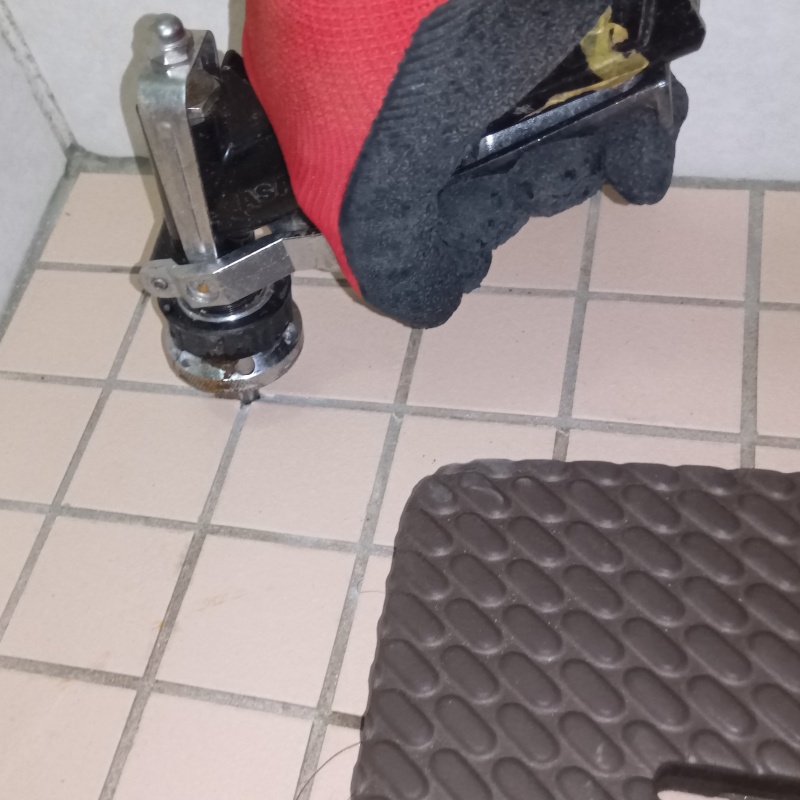 浴室の床にシロアリ駆除を注入する様子