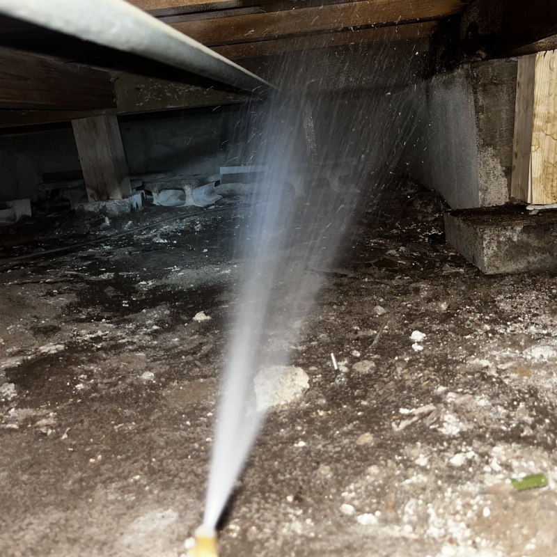 床下の土壌に防蟻剤を散布する様子