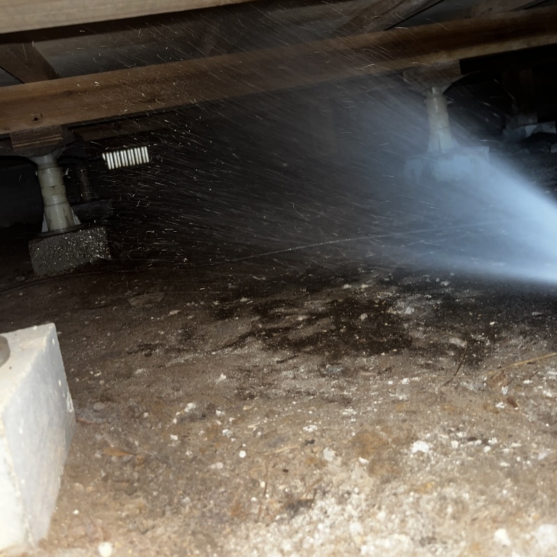 床下の土壌に防蟻剤を散布する様子