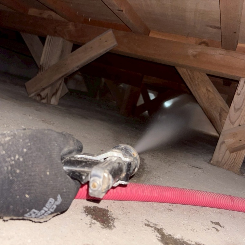 床下の土壌にシロアリ駆除剤を散布する様子