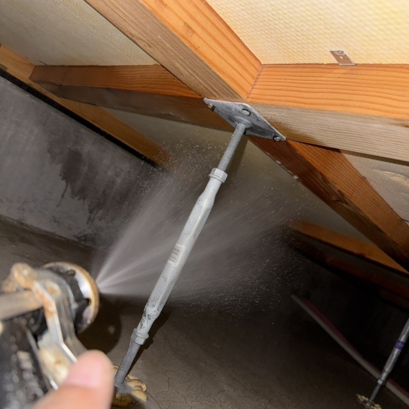 床下の木材に防蟻剤を散布する様子