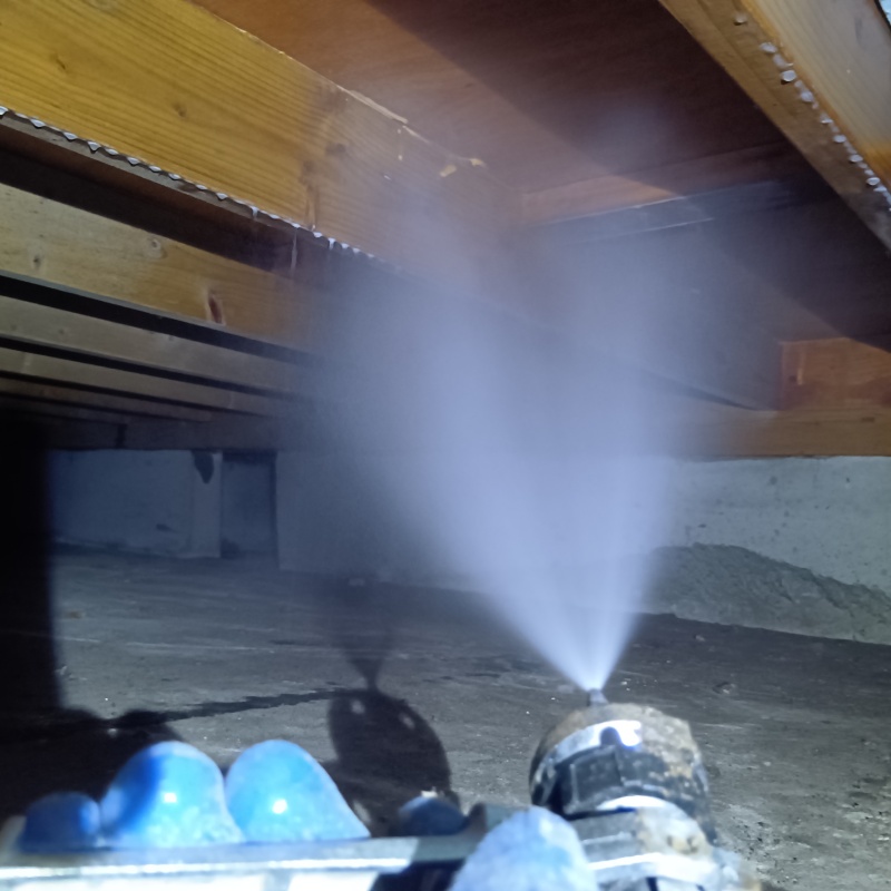 床下の木材にシロアリ駆除剤を散布する様子