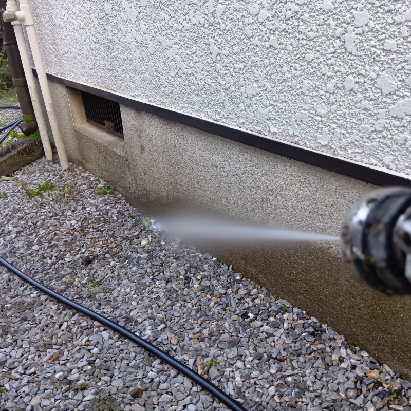 基礎まわりにシロアリ駆除剤を散布する様子