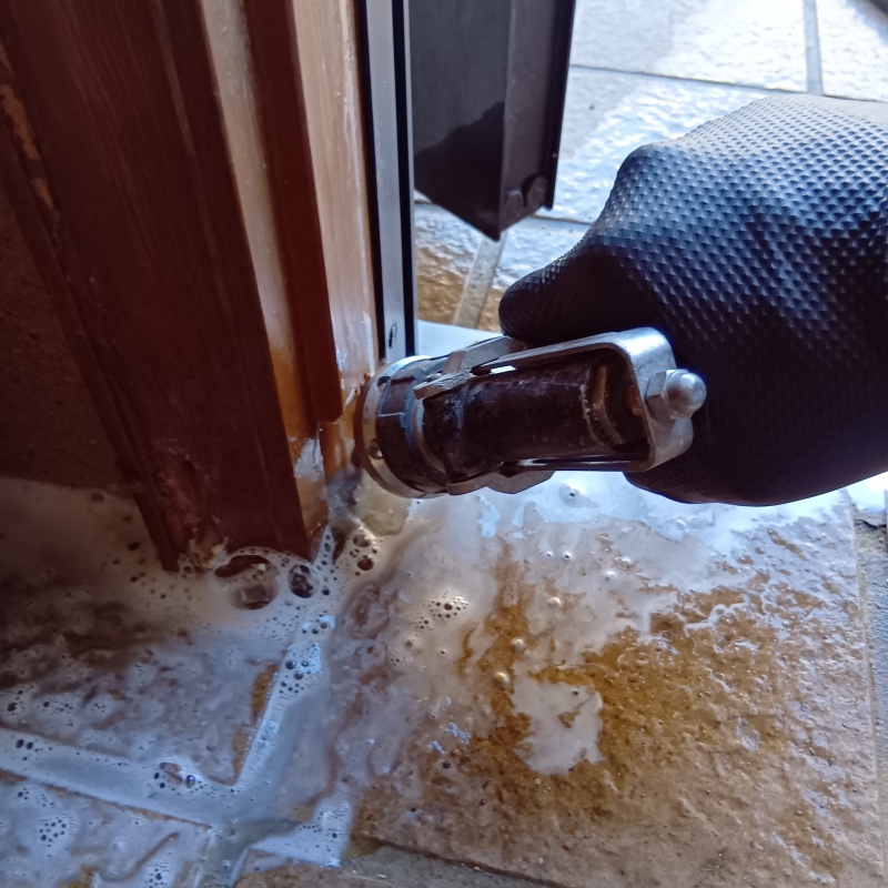 玄関のドア枠にシロアリ駆除剤を注入する様子