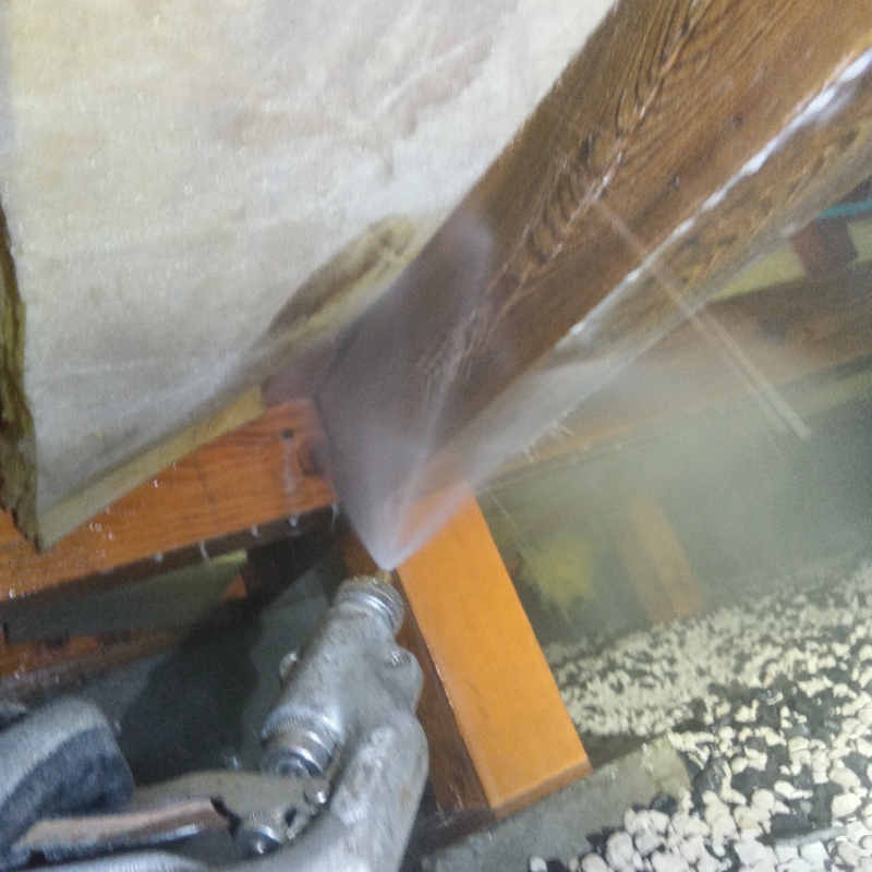床下の木材にシロアリ駆除剤を散布する様子