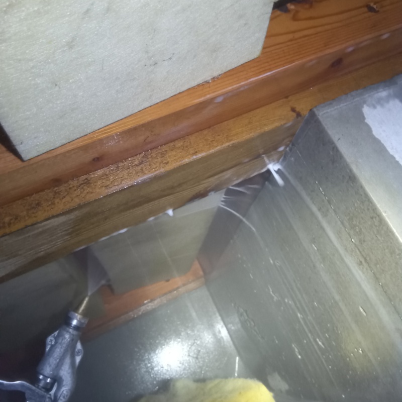 床下の木材にシロアリ駆除剤を散布する様子