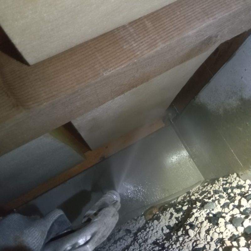 床下の基礎部分にシロアリ駆除剤を散布する様子