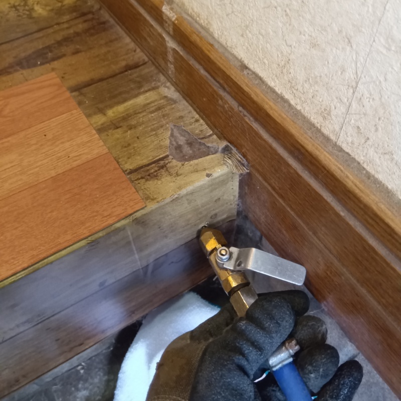 玄関の上がり框にシロアリ駆除剤を注入する様子