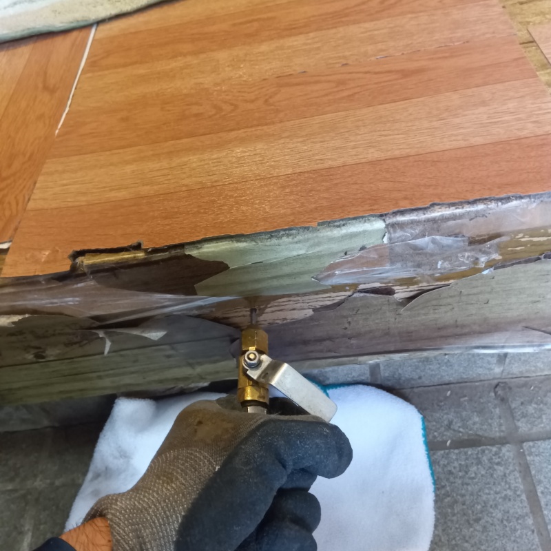 玄関の上がり框にシロアリ駆除剤を注入する様子