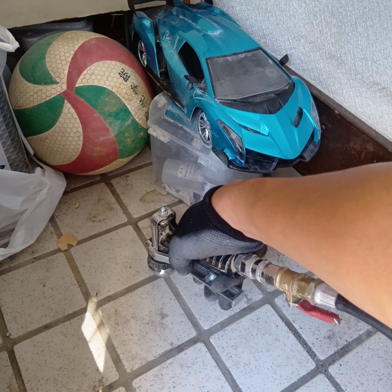 玄関の床にシロアリ駆除剤を注入する様子