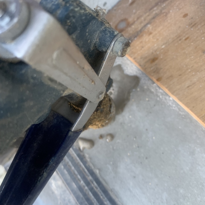 玄関の床にシロアリ駆除剤を注入する様子