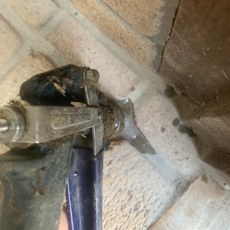 玄関の床にシロアリ駆除剤を注入する様子