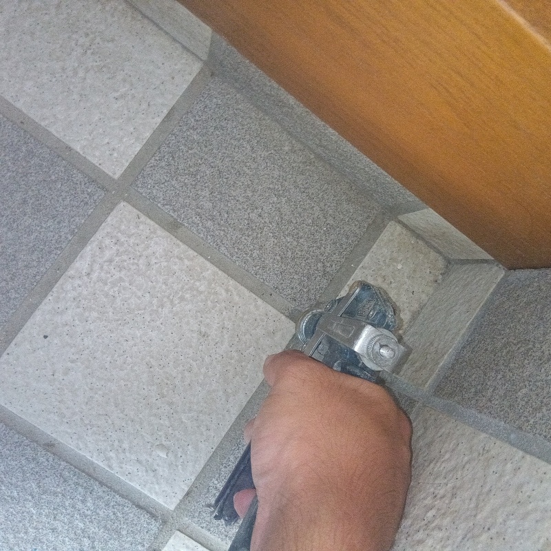 玄関の床に防蟻剤を注入する様子