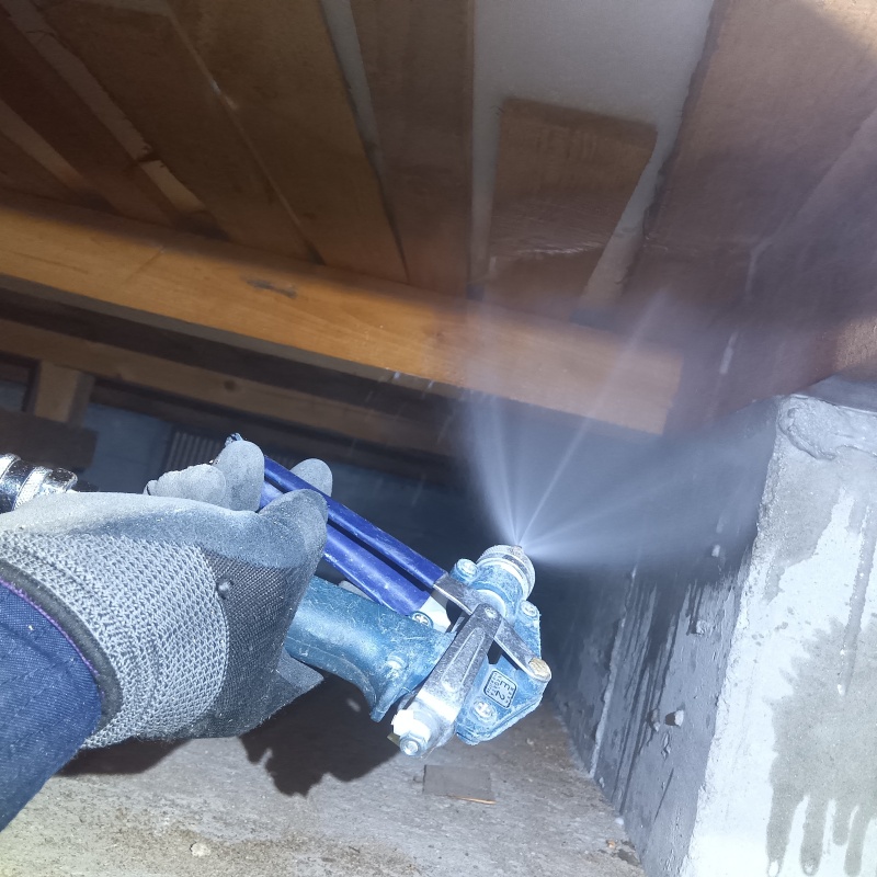 床下の木材に防蟻剤を散布する様子