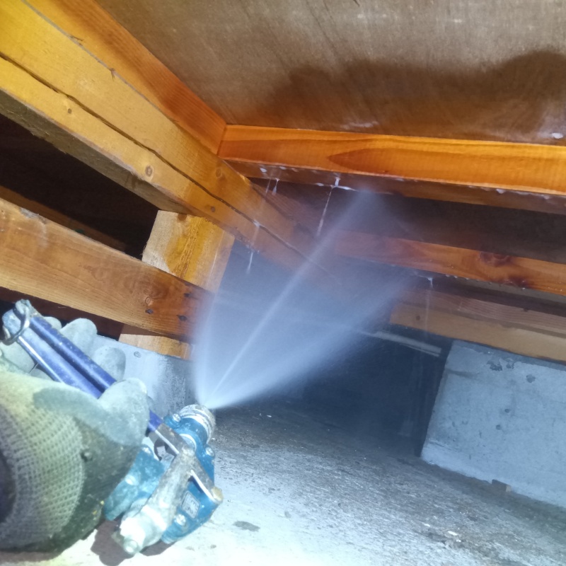床下の木材に防蟻剤を散布する様子