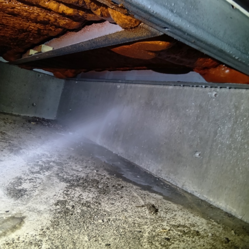 床下の基礎部分にシロアリ駆除剤を散布する様子