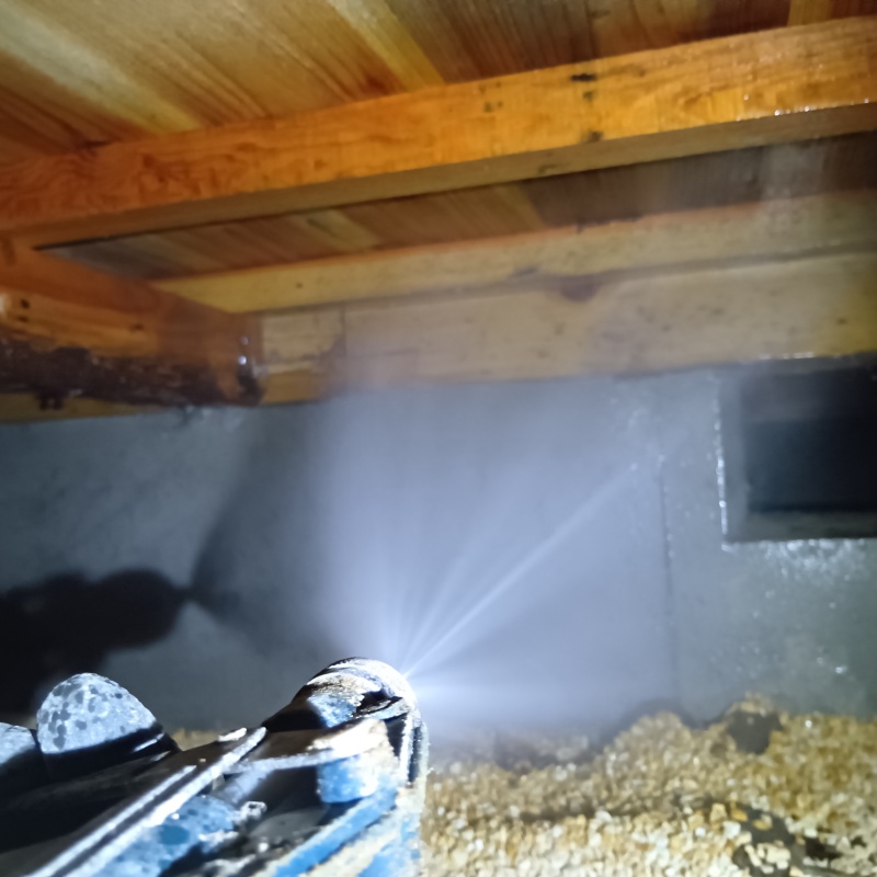 床下の基礎部分にシロアリ駆除剤を散布する様子