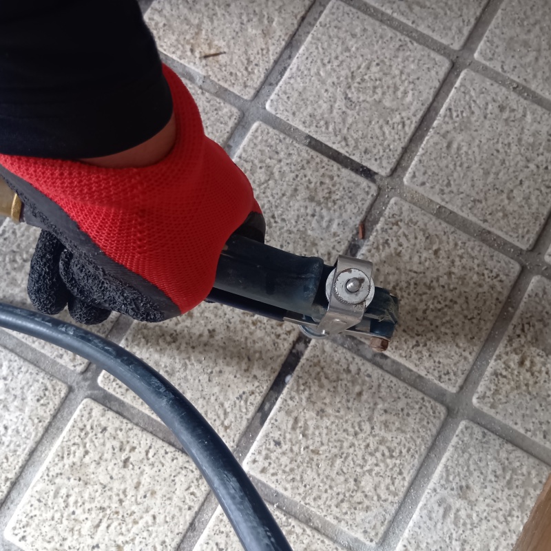 玄関の床にシロアリ駆除剤を注入する様子