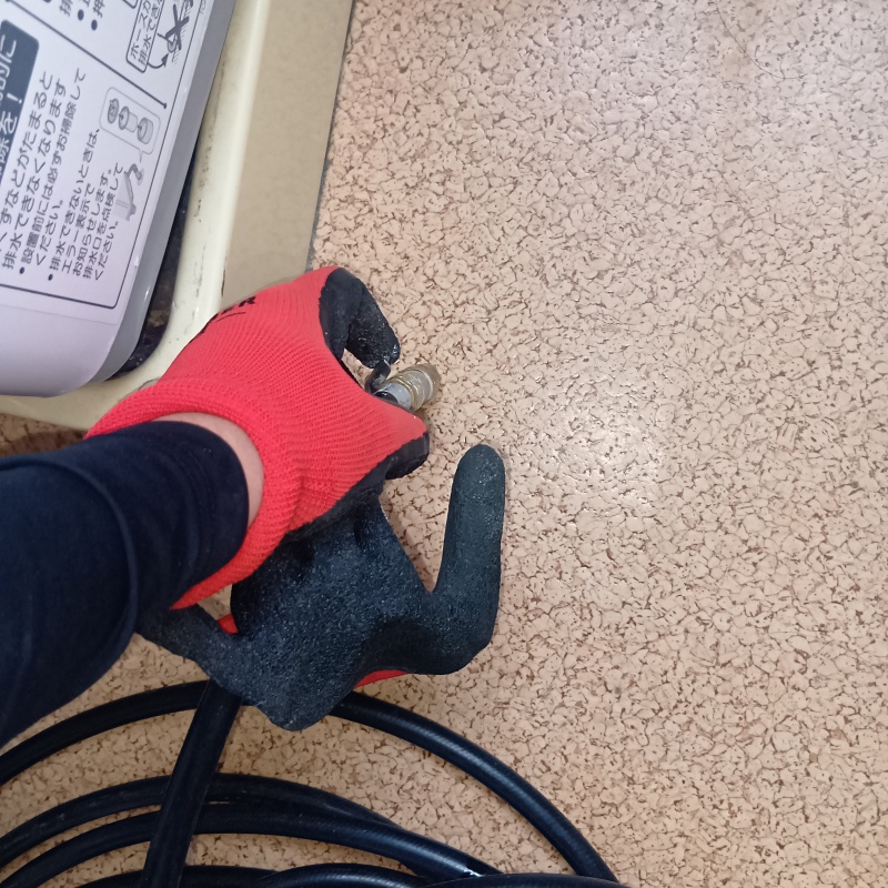 洗面所の床にシロアリ駆除剤を注入する様子