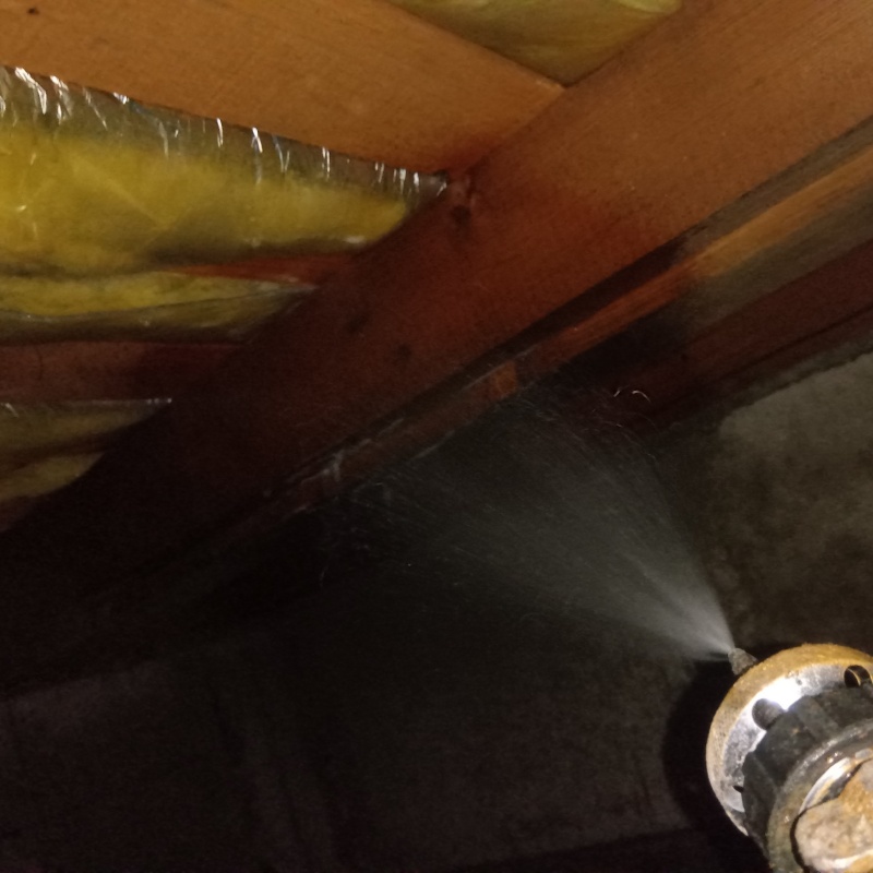 床下の木材にシロアリ駆除剤を散布する様子