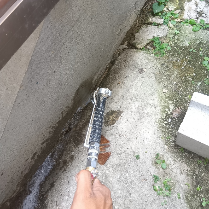 基礎回りにシロアリ駆除剤を散布する様子