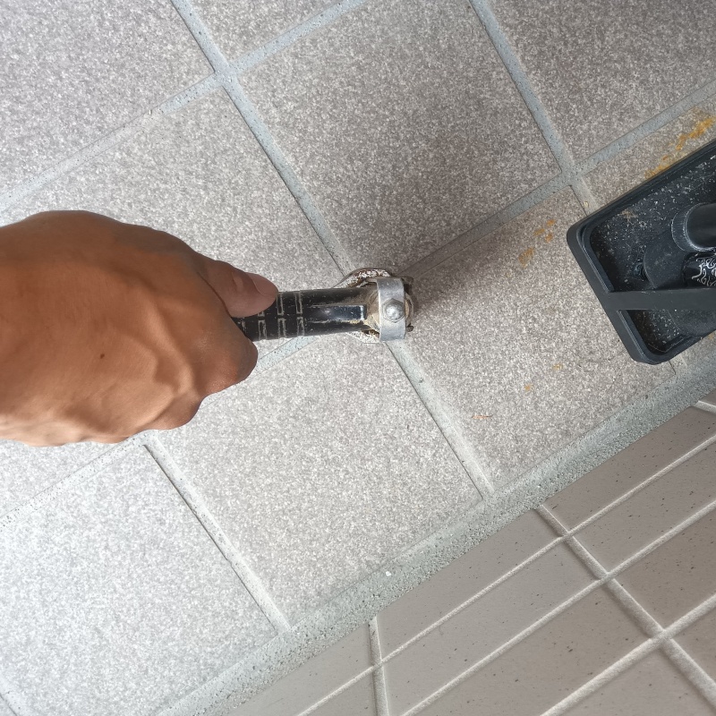 玄関の床にシロアリ駆除剤を注入する様子