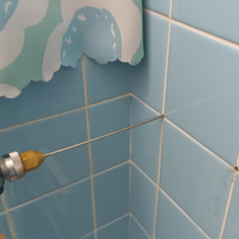 浴室の壁にシロアリ駆除剤を注入する様子