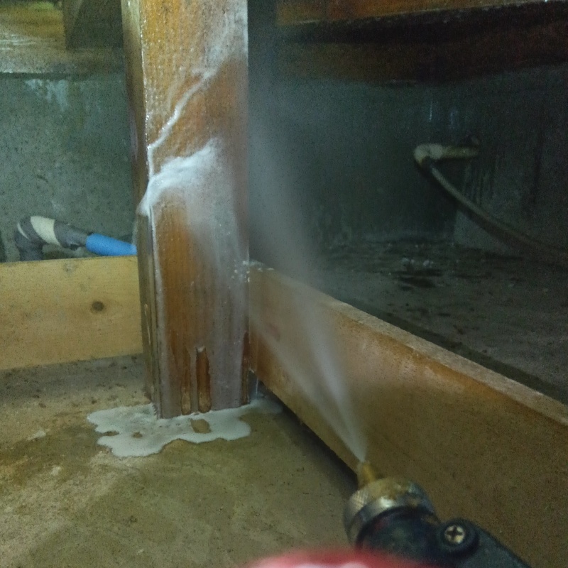 床下の木材にシロアリ駆除剤を散布する様子