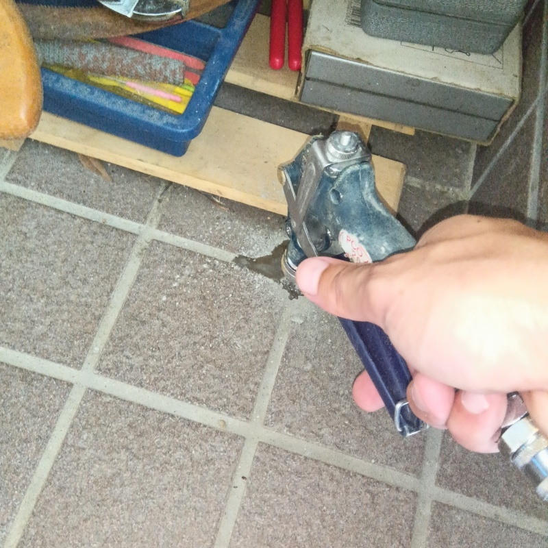 玄関の床にシロアリ駆除剤を注入する様子