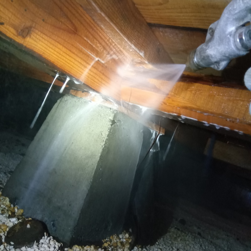 床下の木材にシロアリ駆除剤を散布する様子