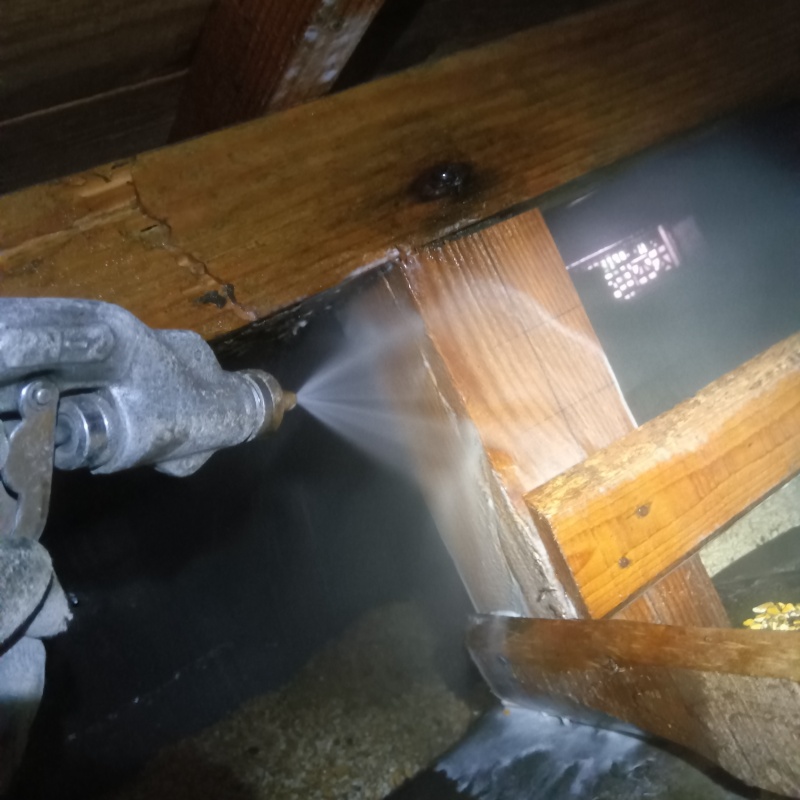 床下の木材にシロアリ駆除剤を散布する様子
